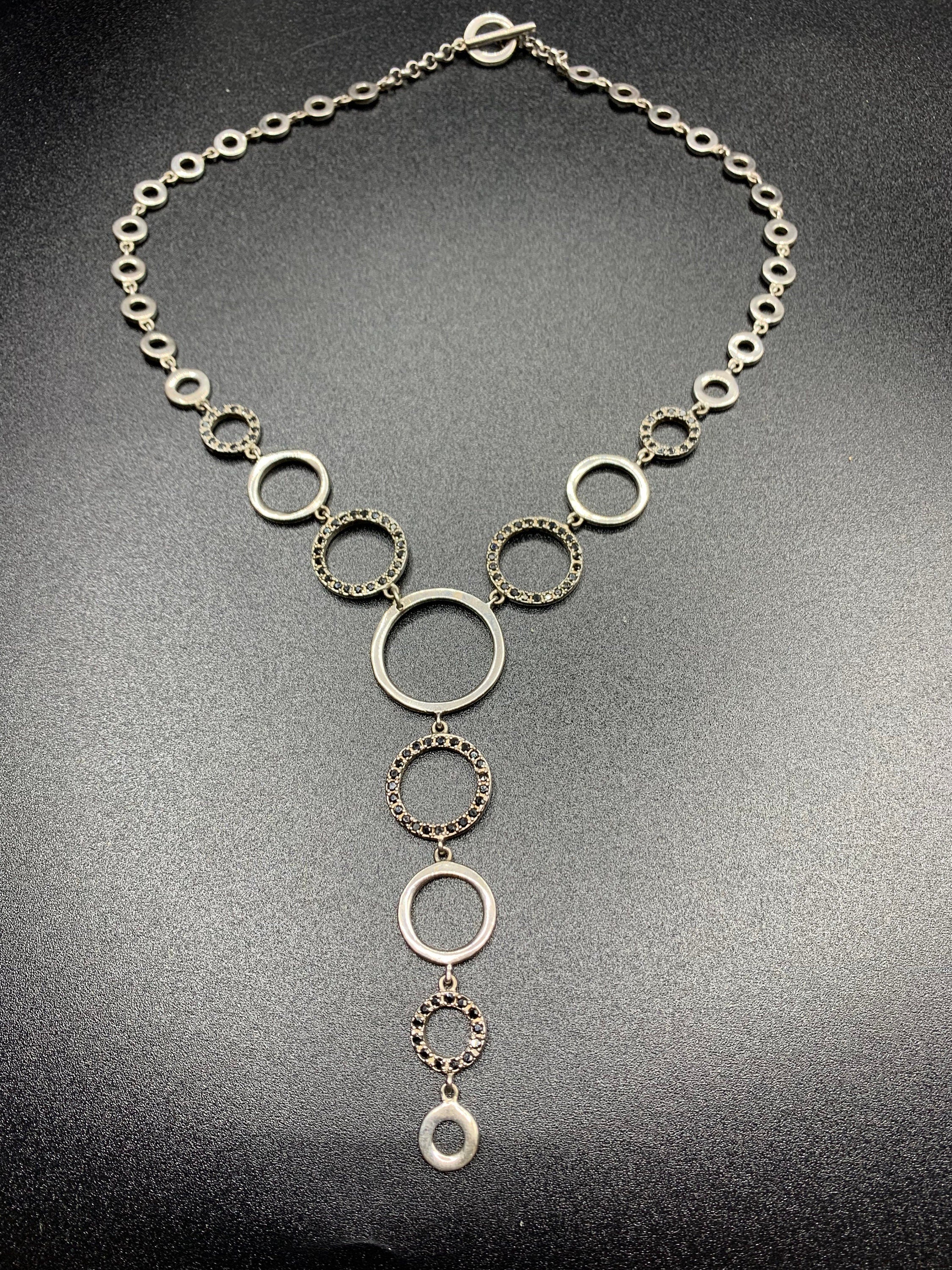 Vintage silver metal choker necklace made of circular various sizes links, some of them decorated with tiny black crystals and form pendant