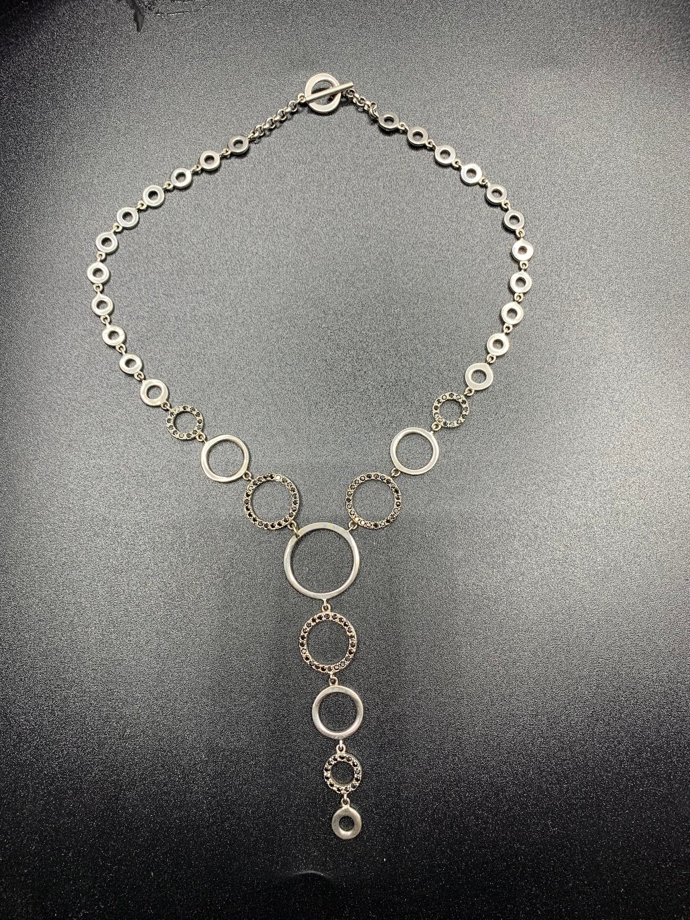 Vintage silver metal choker necklace made of circular various sizes links, some of them decorated with tiny black crystals and form pendant