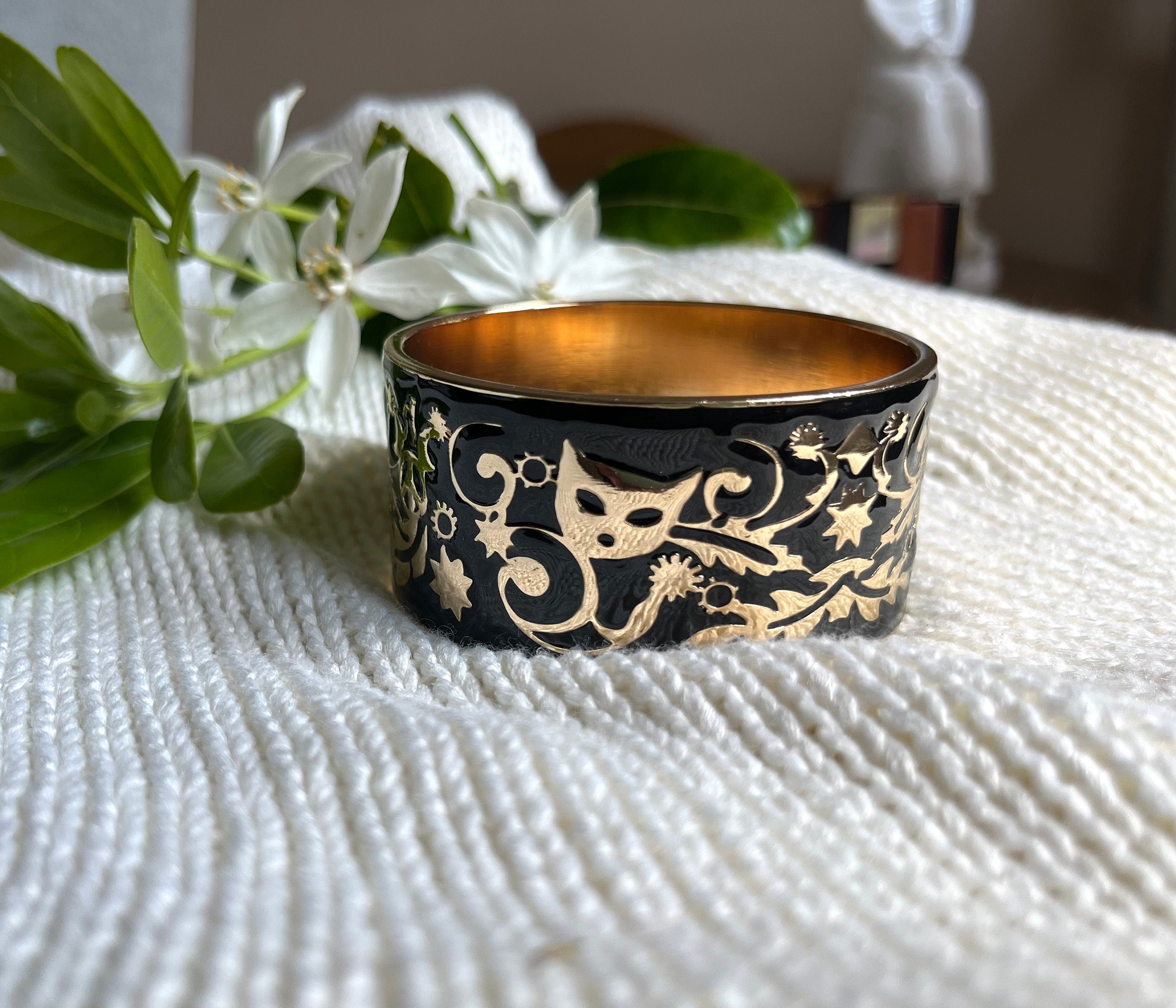 Stunning black enamel on gold metal vintage bangle bracelet with a carved cat mask images on it. Bracelet for a woman. Gift for her.