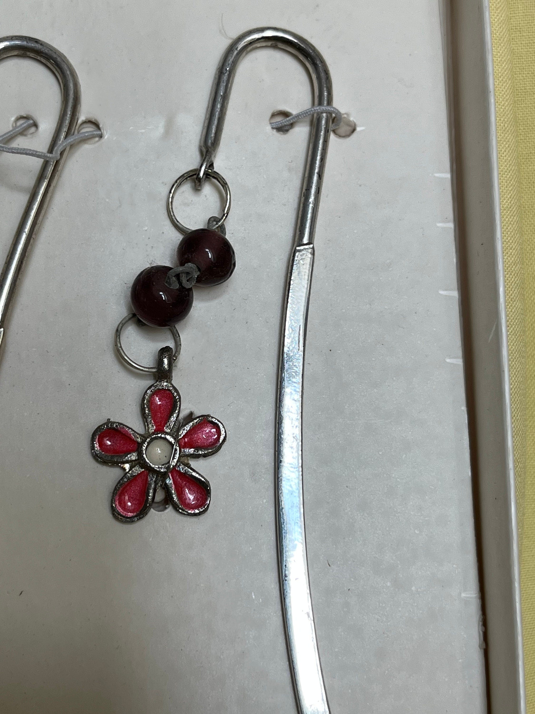 A pair of vintage made in India silver metal and pink glass bookmarks with charms of a butterfly and a daisy